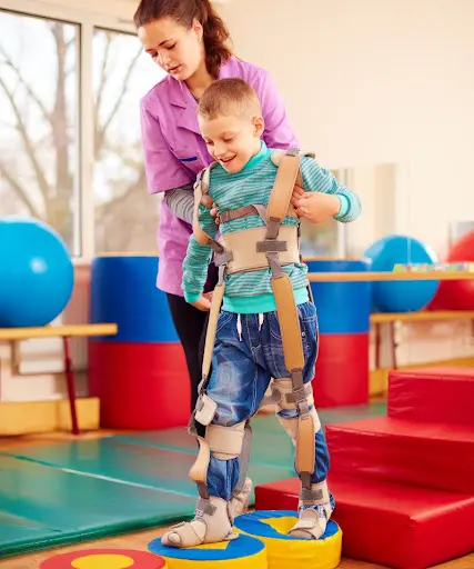 Pediatric physiotherapist guiding a child wearing TheraTogs to improve posture and gait during therapy session