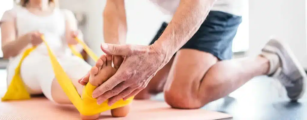 Physiotherapist guiding a patient through prehabilitation exercises using a resistance band